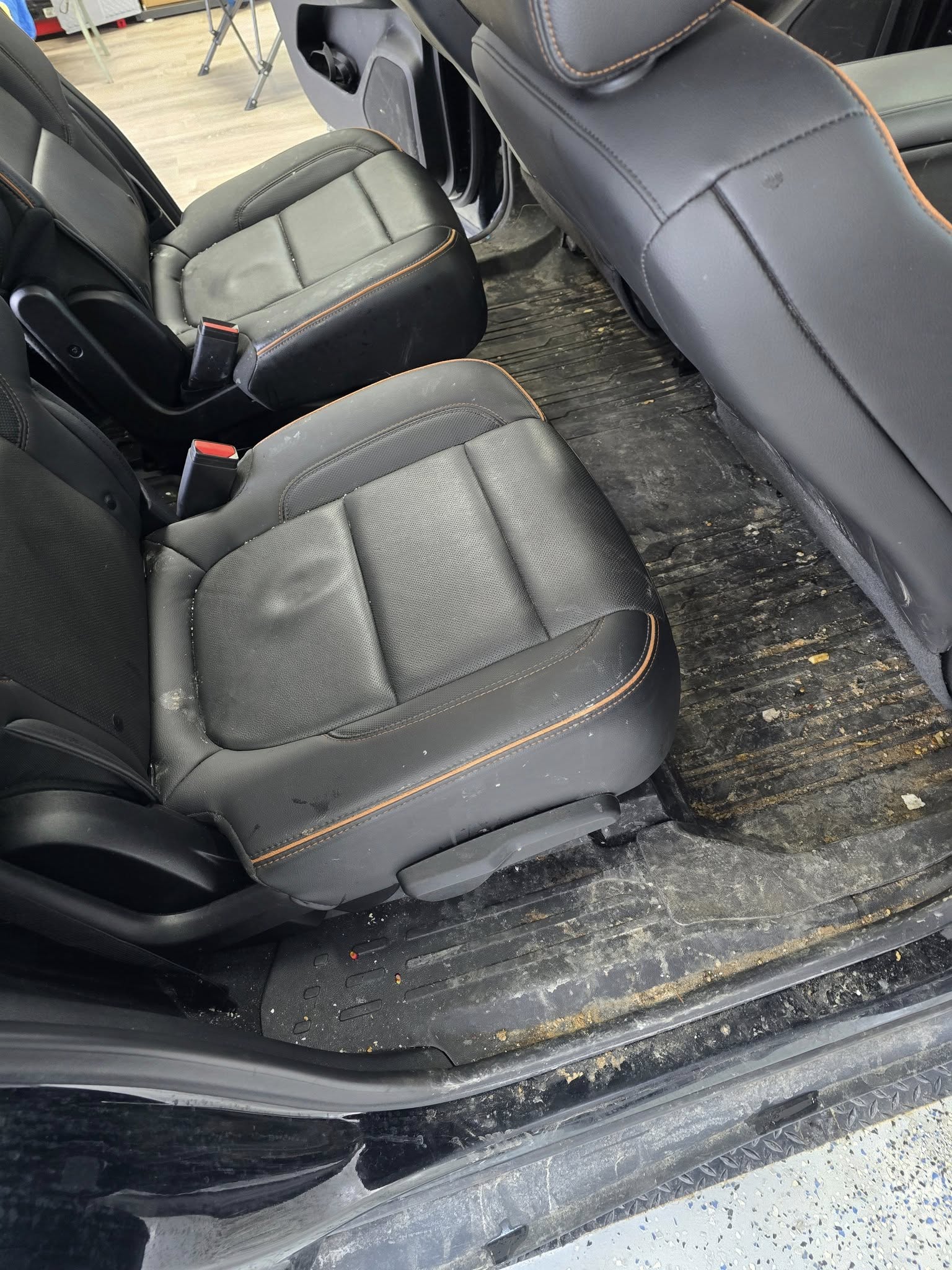 GMC Acadia second-row — BEFORE (dirty floor & tracks)